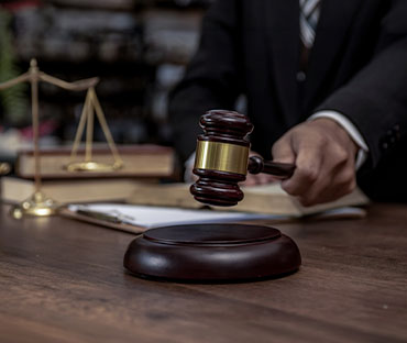 Man hand knocking a wooden judge gavel