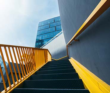 Yellow staircase against skyscraper